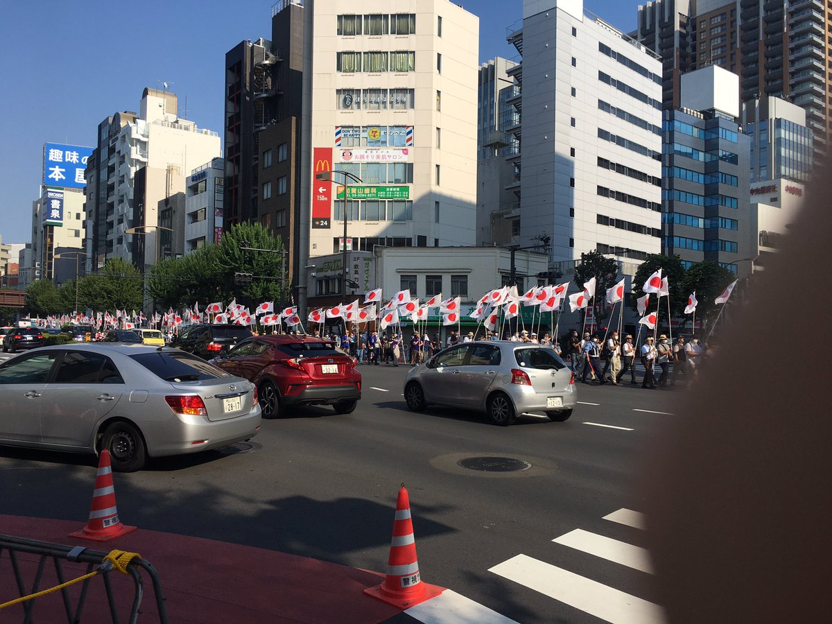 They are now marching down the street towards the shrine. Again you wouldn’t be seeing a sea of national flags like that in Germany, for example.