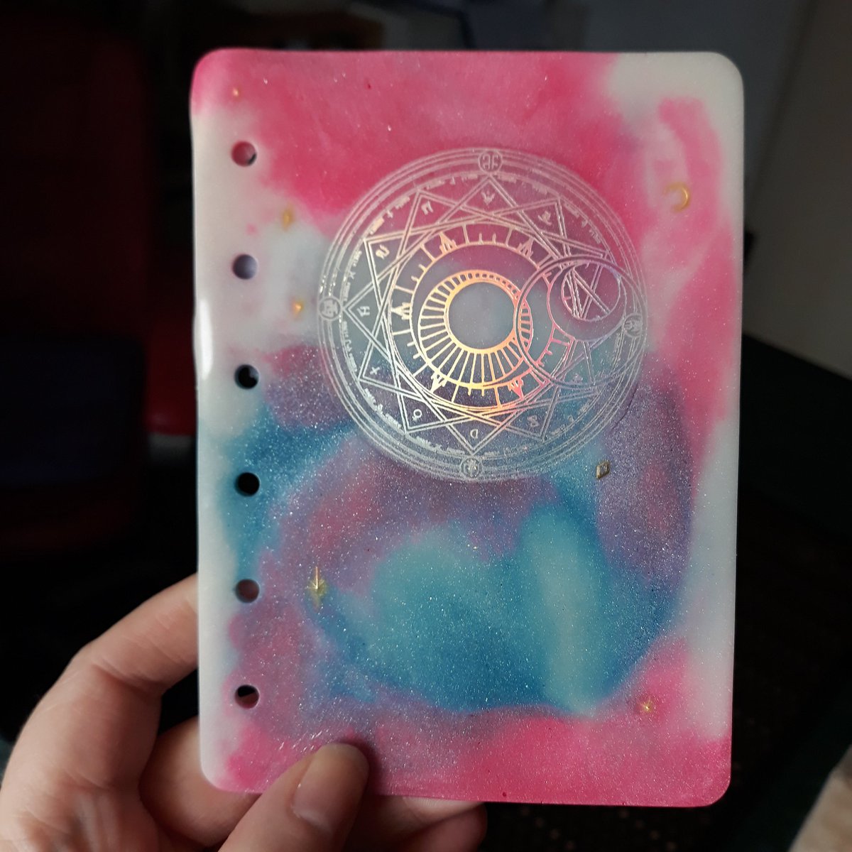 Pandeimonium's tweet photo. Cast this gorgeous notebook. I love how much the colours pop. 
Plus the glow in the dark pigments worked so well.
I just need to procure some more hardware and add some pages.

#Handmade #Resin #CardCaptorSakura #SmallBusiness #DisabledArtist #Notebook #Bookmaking https://t.co/LEXy7hJl56