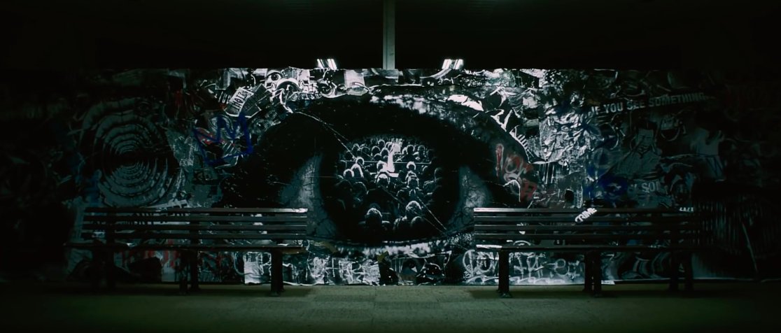 Throughout the MV, there are glimpses of a spectacular mural in the background - a gritty & slightly creepy mixed media artwork.If you look closely, aside from eyes, mouths, & people, you can see phrases like “what are you watching” or “if you see something, say something”.
