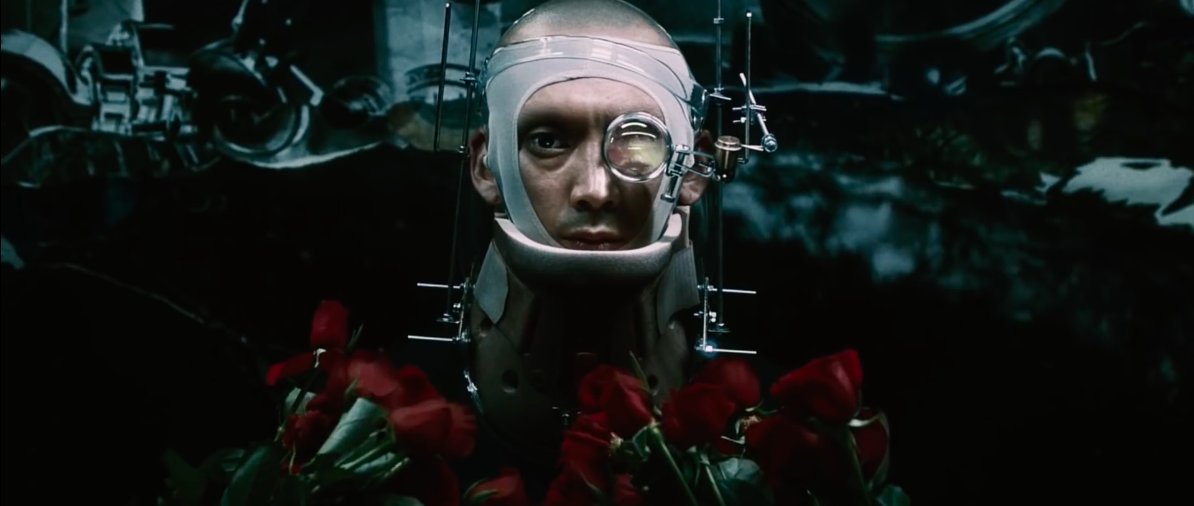The flowers behind main head gear guy- is it actual beauty & truth? The roses he carries- a search for love in a harsh, fabricated world?Lyrics:“I can’t just let things be black or whiteNobody makes anything clear, right?What are we holding onto?What are we desperate for?”