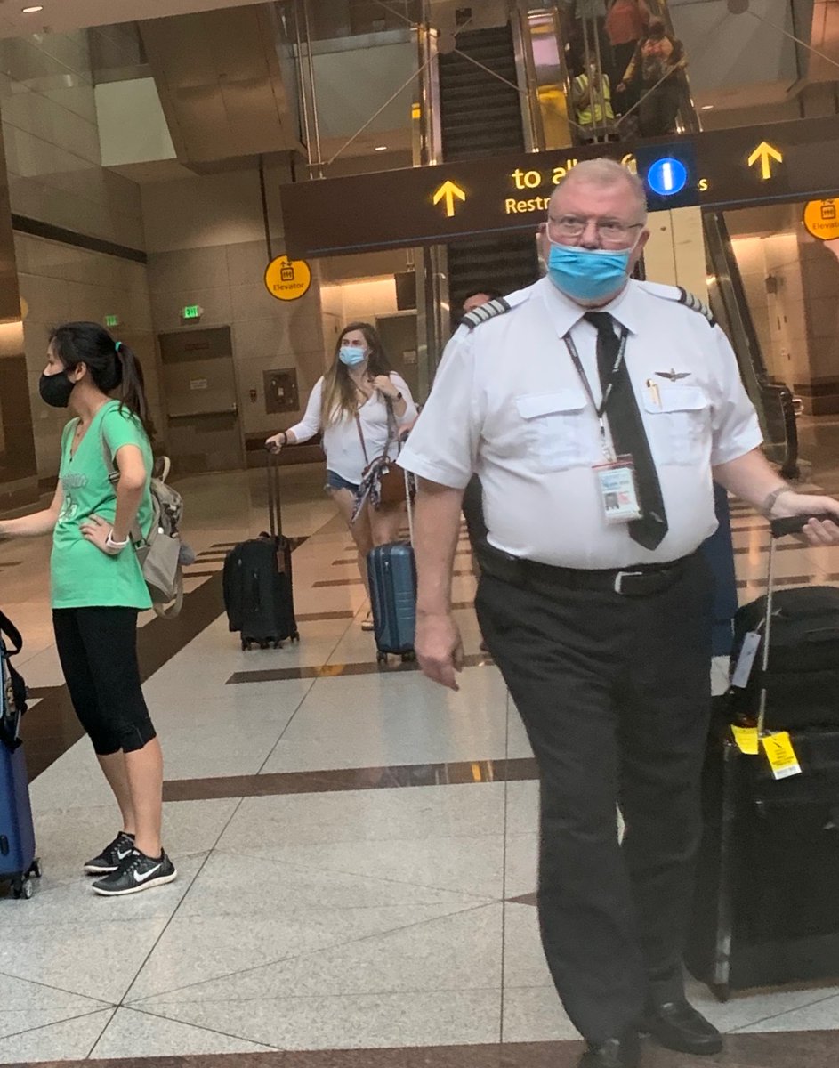 GinaDTucker's tweet photo. Some photos from my @AmericanAir flight- even the pilot was wearing his mask wrong! Many people were standing maskless in the aisles the whole flight. Unacceptable. https://t.co/oV7qvQ4K33