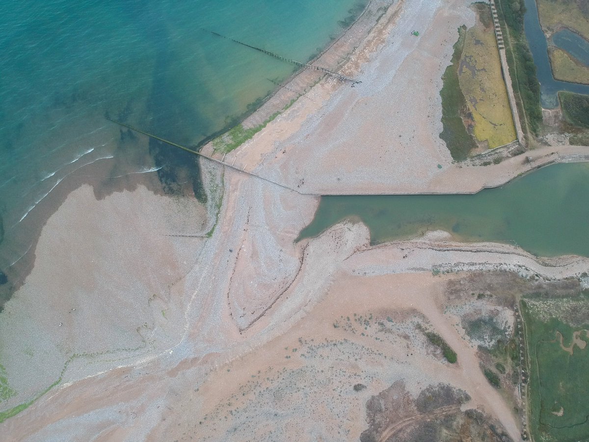 andrewgardnr's tweet photo. Aerial images showing the build-up of shingle where the River Cuckmere meets the sea. The river has not been able to run into the sea for weeks, and is turning stagnant, fish are dying, and it stinks. 
#seaford #cuckmere #southdowns #rivercuckmere #wildlife #sdnp #sevensisters https://t.co/T4LhVxo1TP