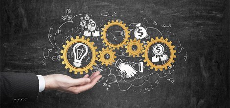 hand holding gears with lightbulb and money inside