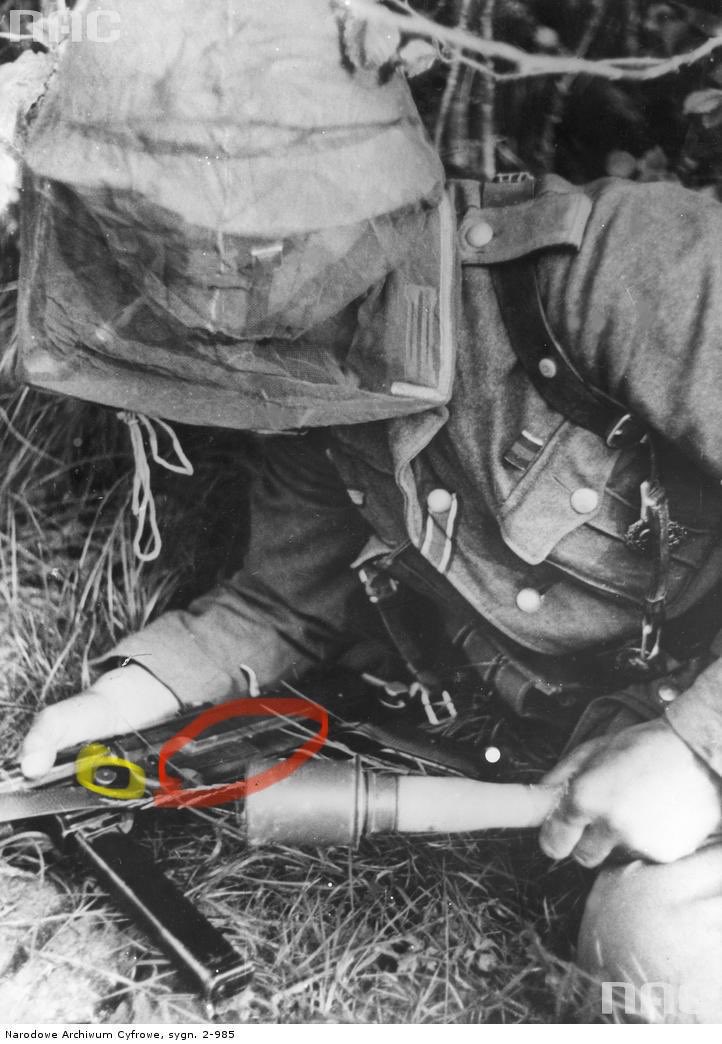 Ok, some fluff. The red is the Bakelite grip (intentioned area to be held with the supporting hand).We often see the magazine housing (not mag) held to mitigate recoil, tho, a la the PPSH41. As a result, accidental release of the yellow magazine button was possible. 20d)