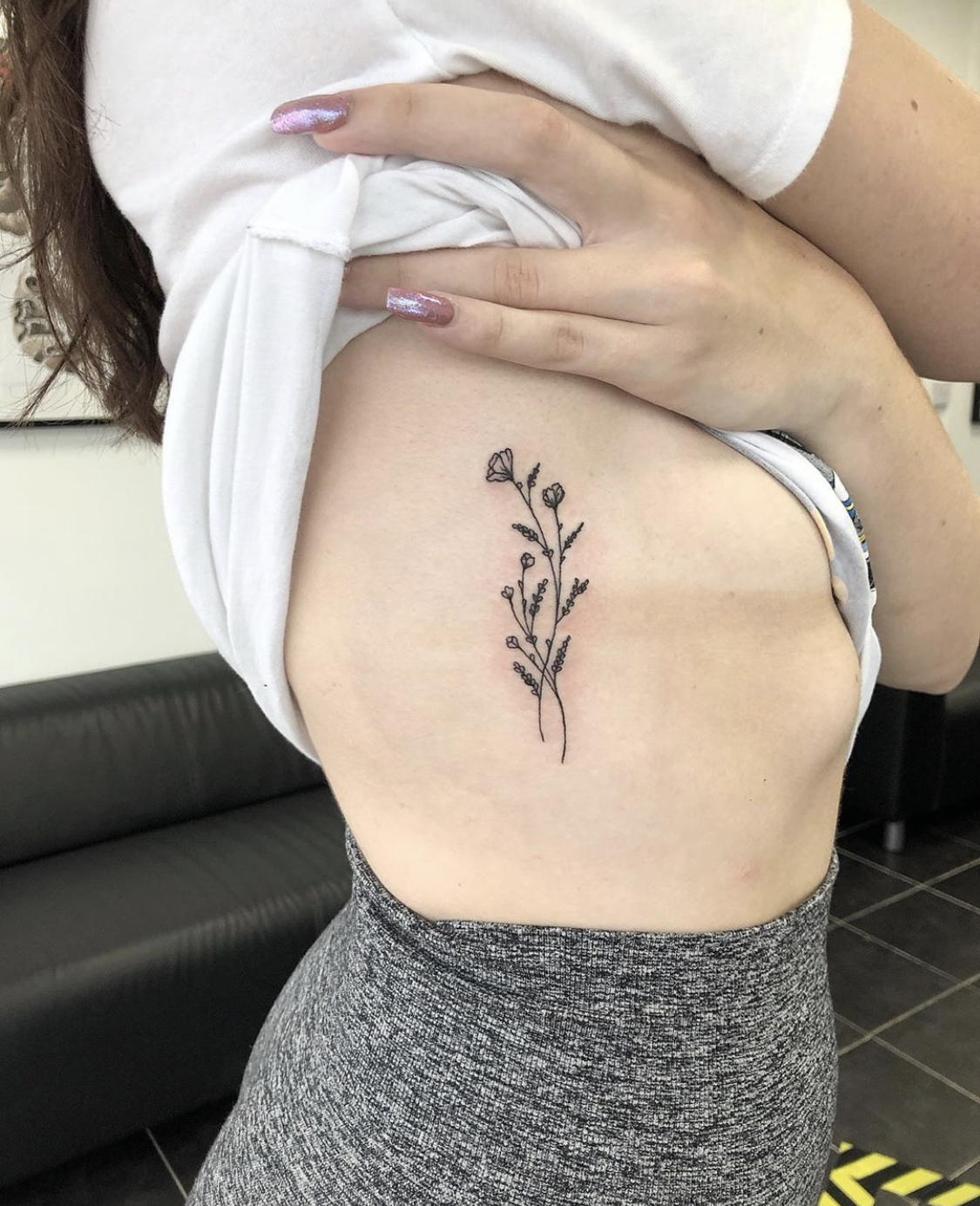 Fine line flowers tattoo on the rib