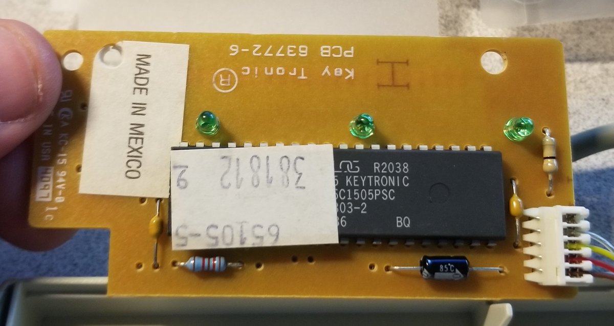 Other side is... stickery.It's a Key Tronic PCB 63772-6, and I don't know why there's a 65105-5 sticker on top of the microcontroller