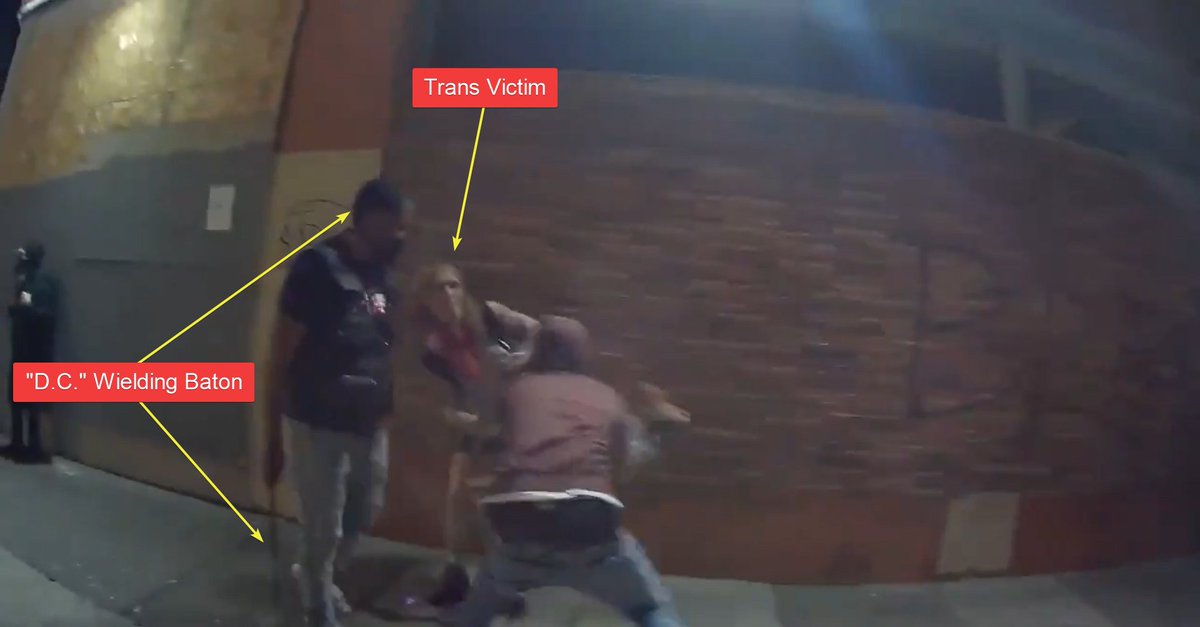 Here he is holding a baton while the trans person is robbed.