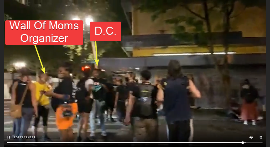 Here he is in a gaggle near Demetria Hester, the leader of the Wall of Moms.