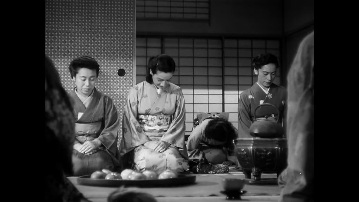 The assistant arrives in a frontal shot with Noriko centered. Notice the five planes here: two shoulders and a cup in the extreme foreground; the tea kettle and cups; Noriko and her aunt; the assistant bowing; and the shoji (sliding doors with paper windows) in the background.