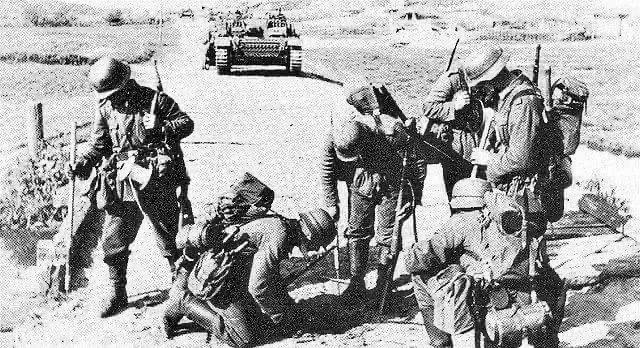 Now thus far, all the pics saw non-specialist men, but here we have 5 Pioniere (Engineers) with 3 of the same poles looking to clear the road for the waiting StuG & other traffic.At least 2 men carry tape, presumably for marking safe paths.4)