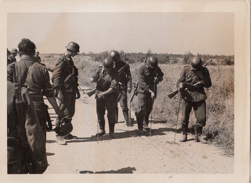Another pic of a mine clearing party, this time with just stiletto probes, without the wooden shaft.The lack of concern from the men moving past perhaps indicates the normality of this scenario.5)