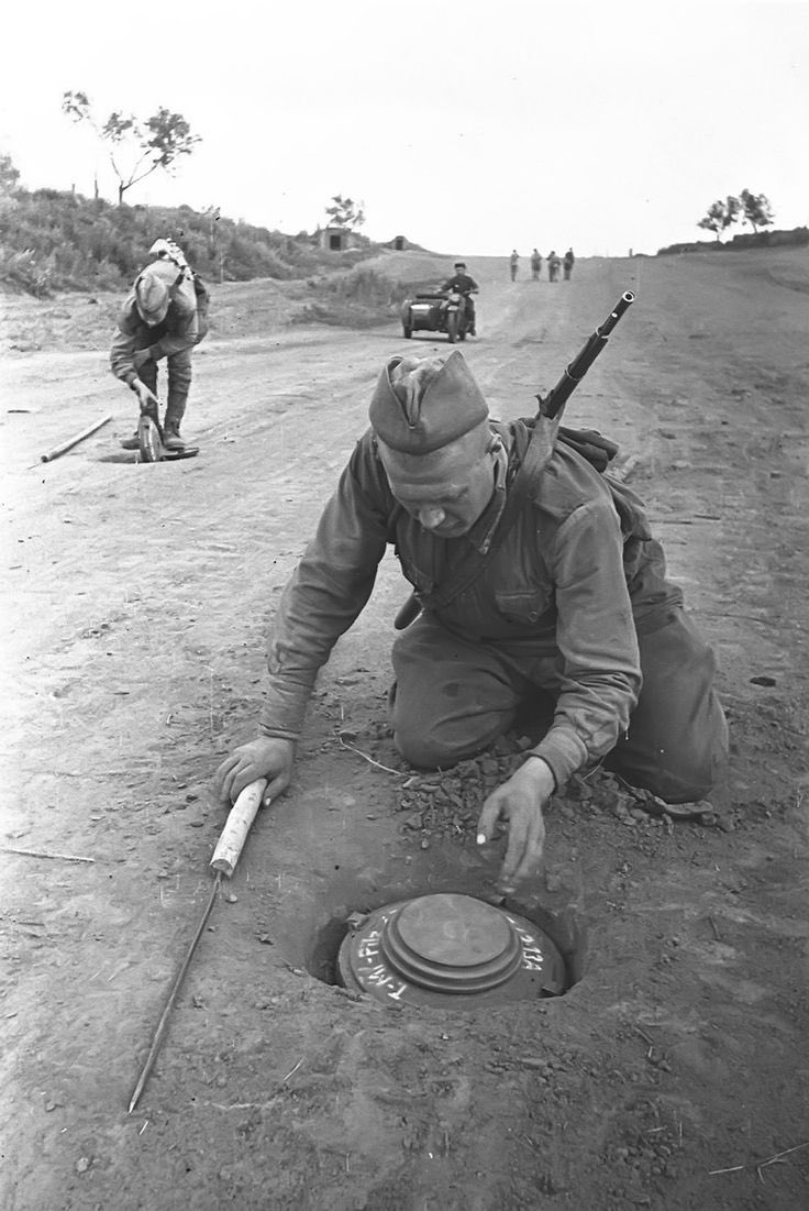 Imagine my delight when I happened across this. Russian use of the same rudimentary tool, as they remove these anti-tank mines from the highway.Great view of the pole nearest the camera.7)