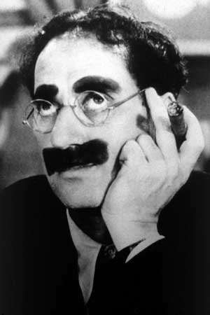 a transformar su profesor en judío.Groucho (de grouch, "gruñón" en inglés), en sucesivos espectáculos fue perfilando su célebre personalidad.El absurdo mostacho pintado con betún (el postizo era incómodo); sus andares casi en cuclillas; cejas pobladas; su puro habano y sus