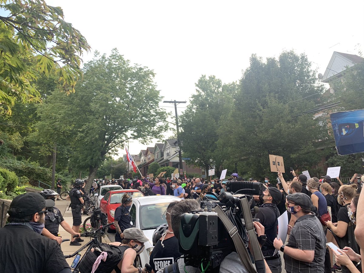 KDKA's tweet photo. HAPPENING NOW: Hundreds of protesters are outside of Pittsburgh Mayor Bill Peduto's house. They are calling for his resignation after plainclothes police officers arrested a man into an unmarked van. 
READ MORE: https://t.co/GQFibnPL6G https://t.co/zjVrDmKLdM