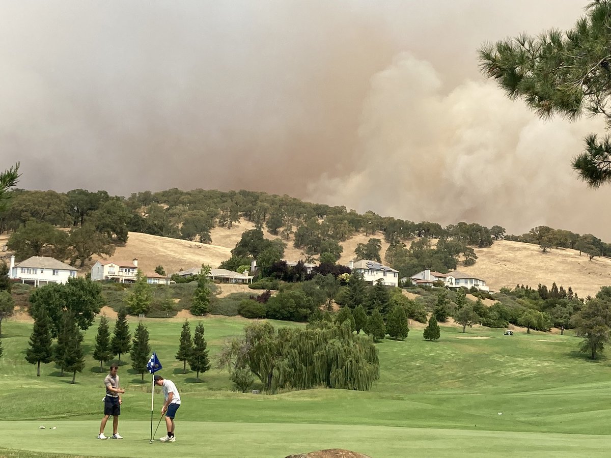 Very California shot: Golfers putt on Rancho Solano Golf Course green as  massive #Vacaville fire glows over the ridge #LNULightningComplexFire  #LightningComplex @sfchronicle