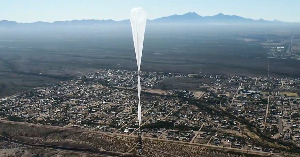 A high altitude balloon drifts above a town.