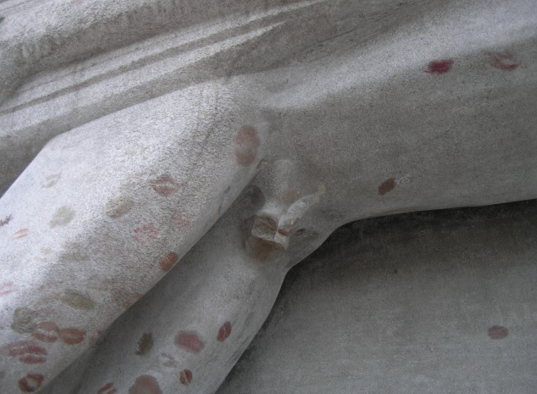 Some time in the '60s, the angel's genitals were smashed off. Urban legend has them being used as a paperweight in the Père Lachaise office, but who knows. The tomb remains with only a little stump (and an ugly barricade to try to prevent the smooching).