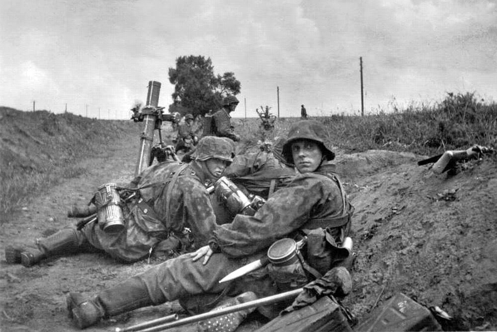 Two nice observations of kit carried by this 8cm Gr.W.34 Gruppe.First is the white painted line on the barrel, used as a guide for ‘rough laying’ of the weapon, when no sight is fitted.The second is the cleaning brush in the foreground, next to the ammo boxes.24)