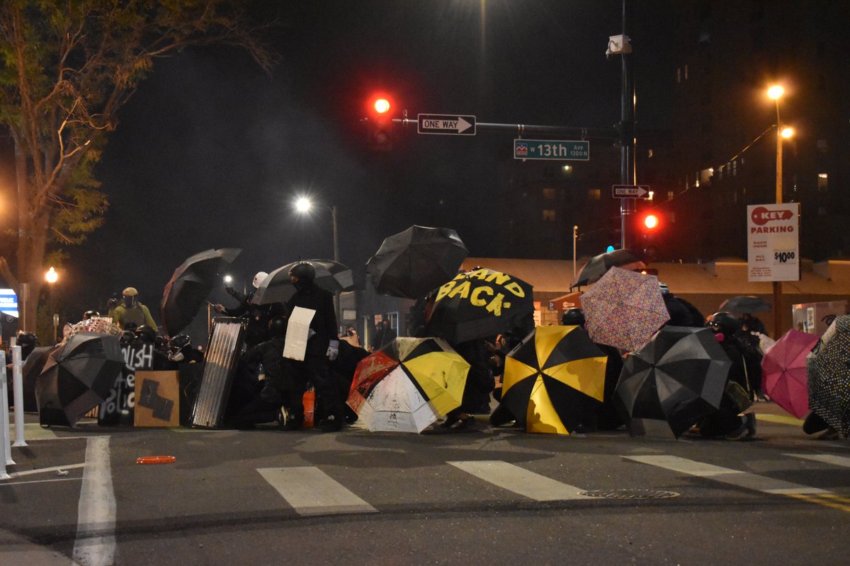 TroutBoneless's tweet image. Protesters form a shield wall as police begin to open fire with pepper balls and tear gas. #DenverProtests #DefundPolice #BlackLivesMatter #LandBack