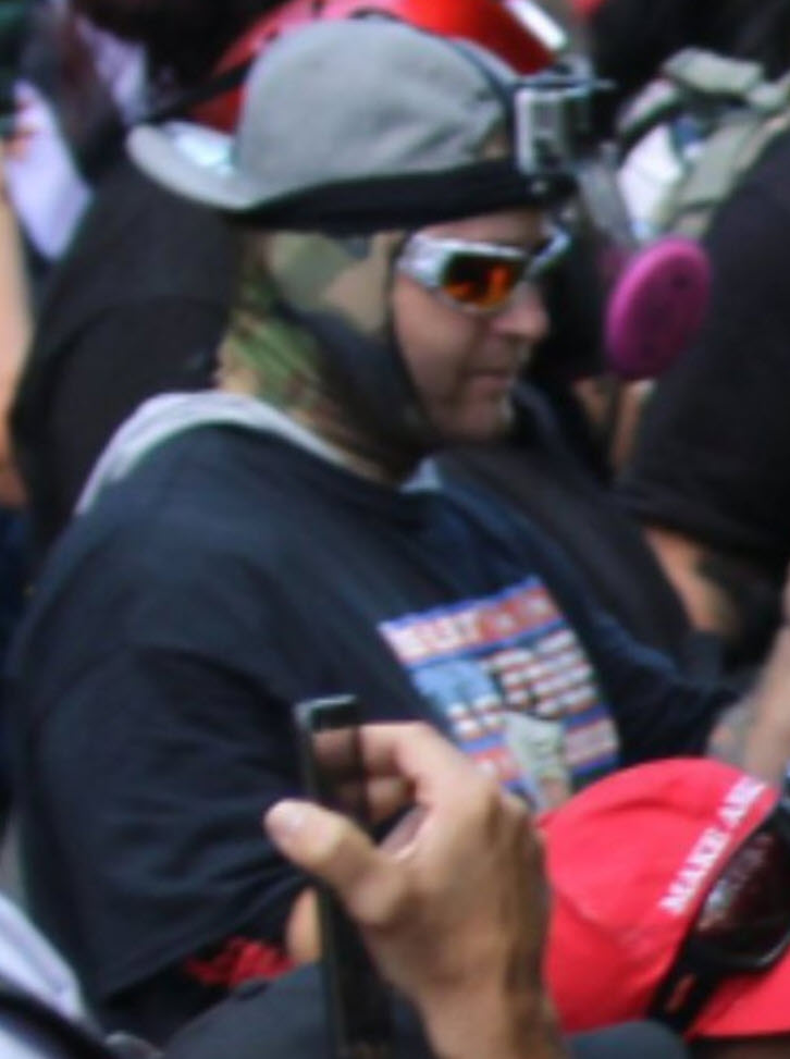 A few more photos of him, where you can see some obvious details (Trump shirt, GoPro camera, flat-brimmed USA hat with sticker still on, camo face covering, etc)