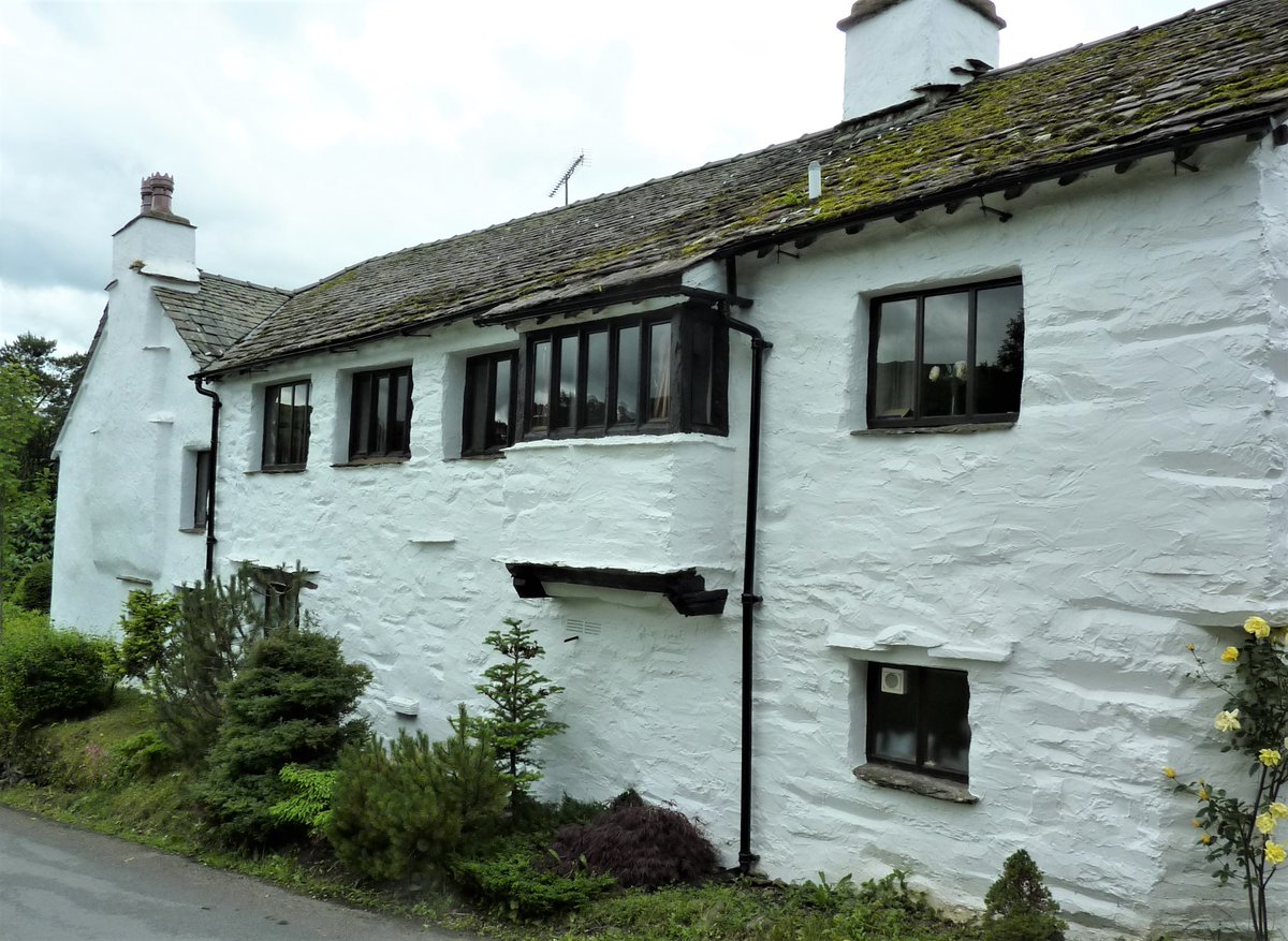 L-shaped house with larger older wing having an unusual oriel window projecting on short timber cantilevers, formerly with door below. Later wing has a corbelled chimney and contains a cupboard dated 1674. Granary extension at nearest end. Troutbeck, Cumbria. #VirtualVernacular