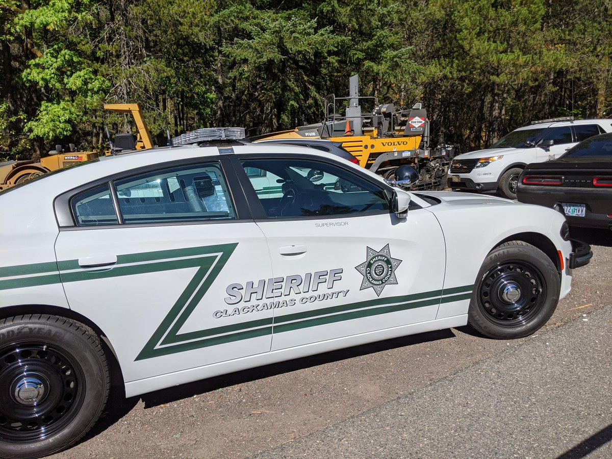 Sheriff approaches the Supervisor vehicle, sits for a moment, emerges wearing a face mask. Stops back at the group and is now on a radio or phone, has been for a number of minutes.  #26rd27