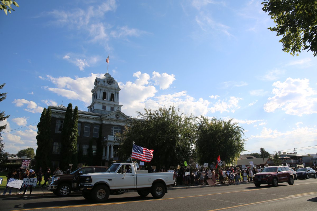 The conflict spread offline into weekly protests and counterprotests.In front of the county courthouse distinct groups face off from either side of a state highway. Passing traffic revs and honks.