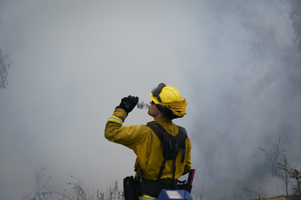 Firefighter Cody Nordstrom, of the North Central Fire station out of Kerman, Calif., takes a water break while fighting the CZU Complex Fire. (AP Photo/Marcio Jose Sanchez)
