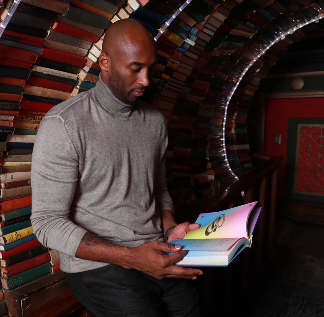 Kobe Bryant reading a book in a tunnel of books at The Last Book Store in DTLA.
