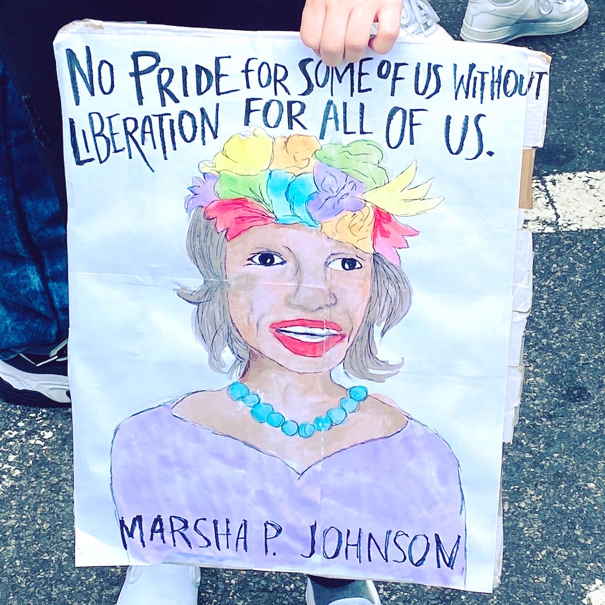 A protest poster shows a drawing of Marsha P. Johnson and includes the quote: "No pride for some of us without liberation for all of us."