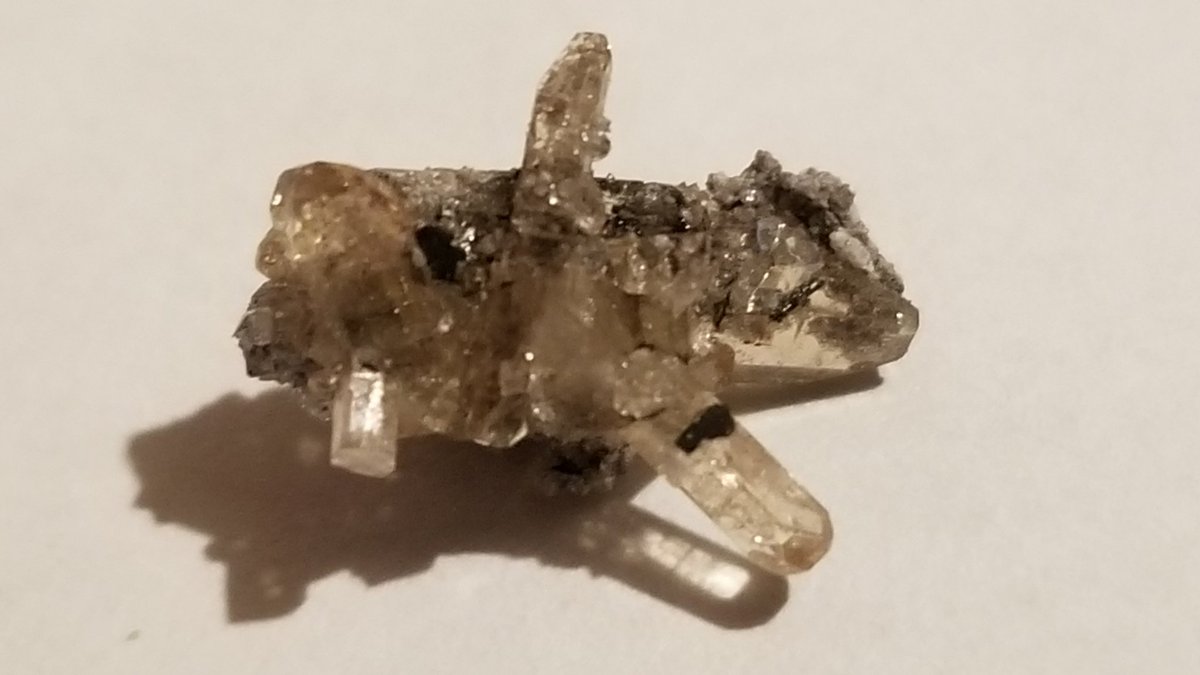 here are some topaz crystals still attached to the material found on the inside of vugsa vug is a cavity in a rock lined with mineral crystals