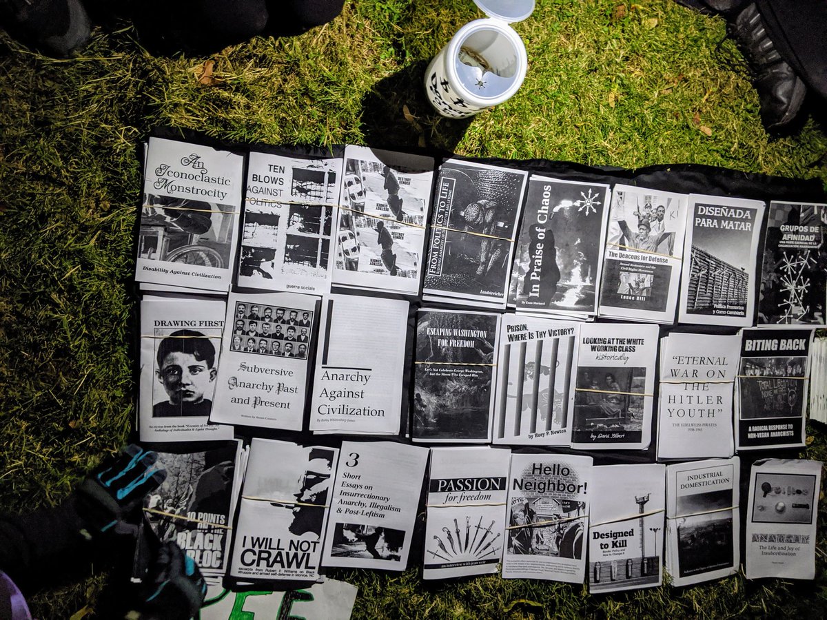 Protesters waiting and gathering. A medic tent distributes water, ear plugs, masks, snacks, and moreNearby, a couple activists have set up a zine station. Very cool