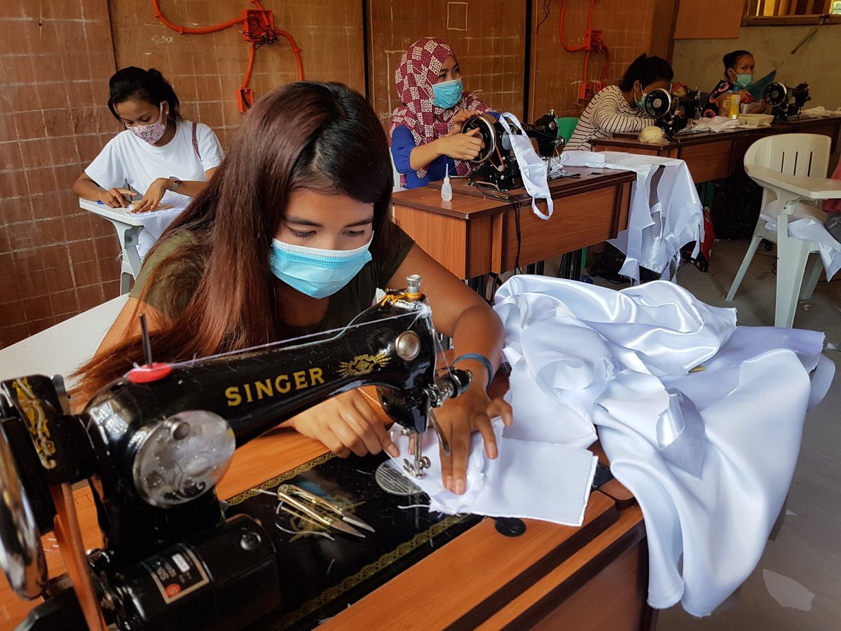 planphilippines's tweet photo. 👀LOOK: #TechVoc practitioners sew face cloth coverings (following CDC protocols) for #COVID19 frontliners in Maguindanao 😷

Shukran! 💙

We hope they inspire other young Filipinos to help others in their own simple ways 🙌

#ReachMindanao
#YouthEconomicEmpowerment https://t.co/9TwGa1f1ow