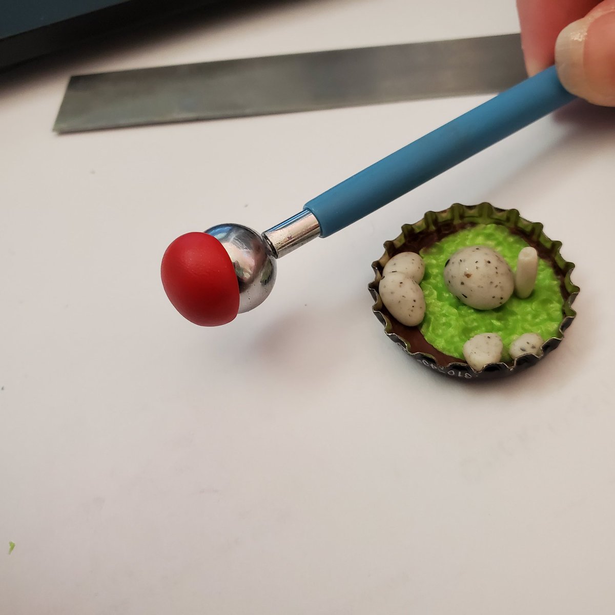 We're making a fly agaric mushroom. Take some red clay and fashion a bowl shape. I used a ball tool but you can do this without. Then take the same color clay that you used for the stem in the previous step and fill the "bowl" with it.