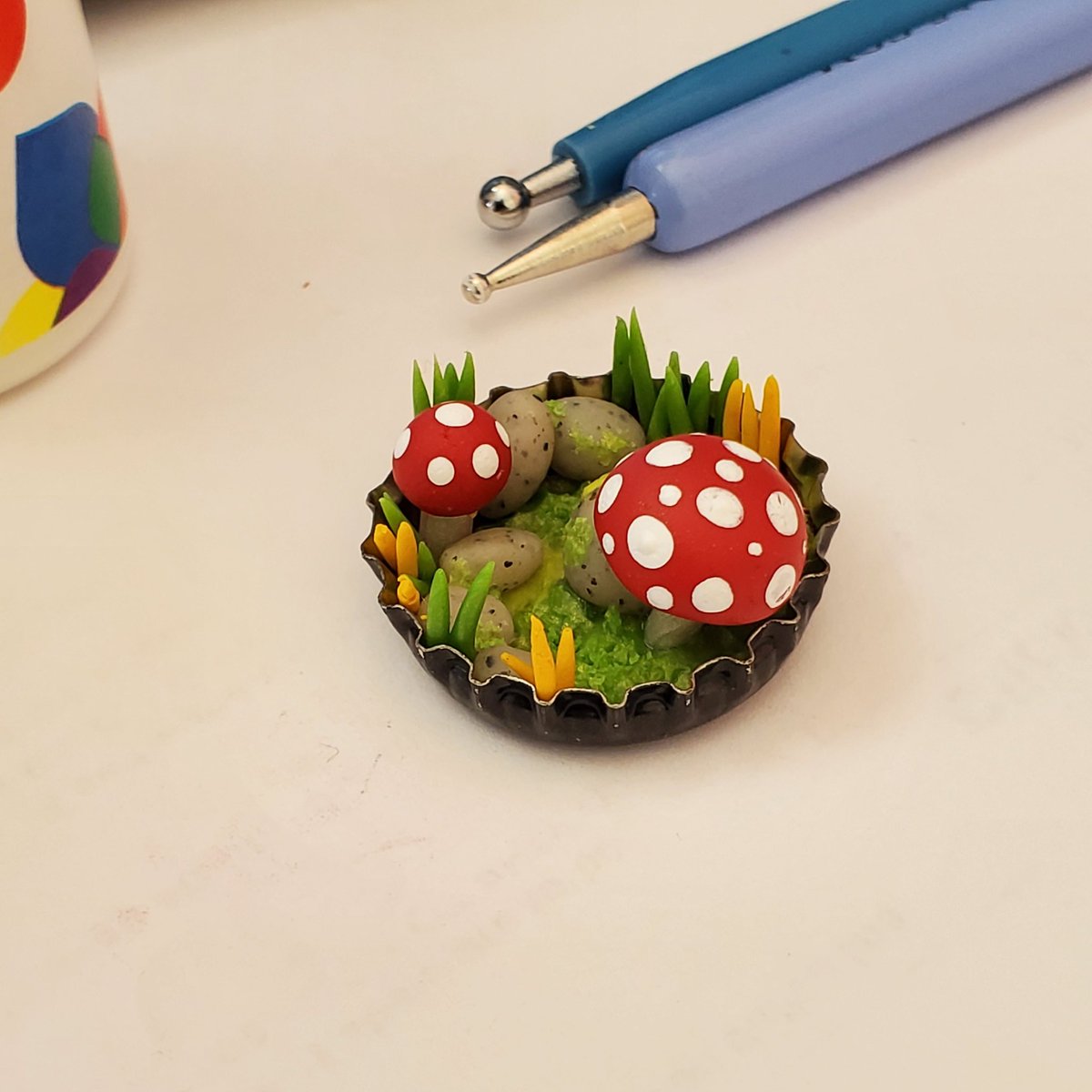Once it's cool enough to touch, use a dotting tool or a toothpick to paint white dots on the mushroom. Acrylic paint is fine.