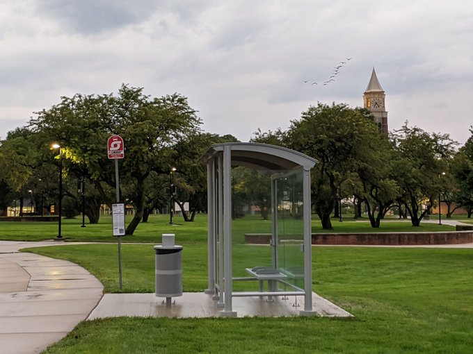 SMART sign and new trashcan next to bus shelter at Oakland University with Elliott Tower in the background