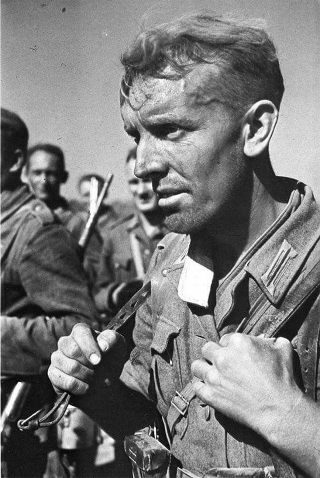 Close-up detail of the Kragen binde (collar liner) to prevent chafing from his M40 tunic, attached by 3 buttons. This was as German service shirts were collarless early to mid-War. He’s holding an auxiliary strap (of his Y-straps) in his right hand. 31)