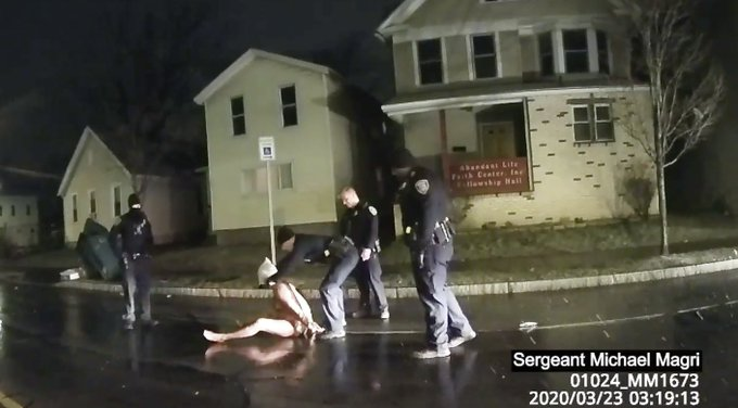 There are so many abuses even in this still photo. Now that he is handcuffed, why is he sitting in the snow, naked against the pavement, getting frostbite? Don't these cops have a blanket in one of their cruisers? For real? Does anybody have a jacket? Or just put him in the car!