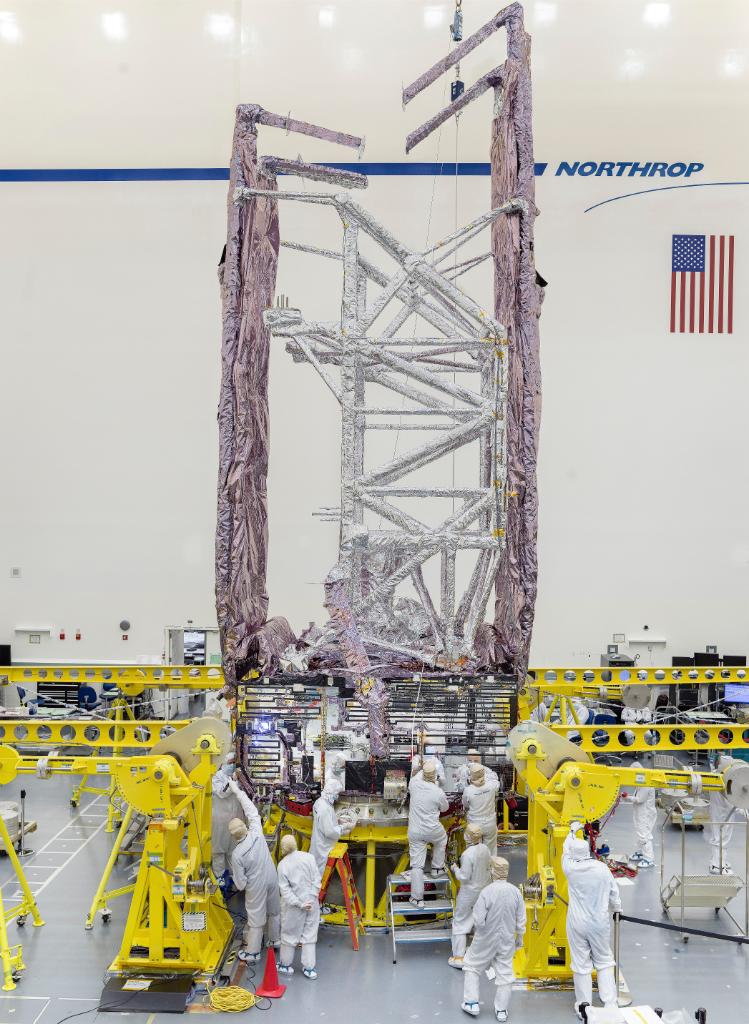 The sunshield folds around the telescope element simulator (silver lattice).