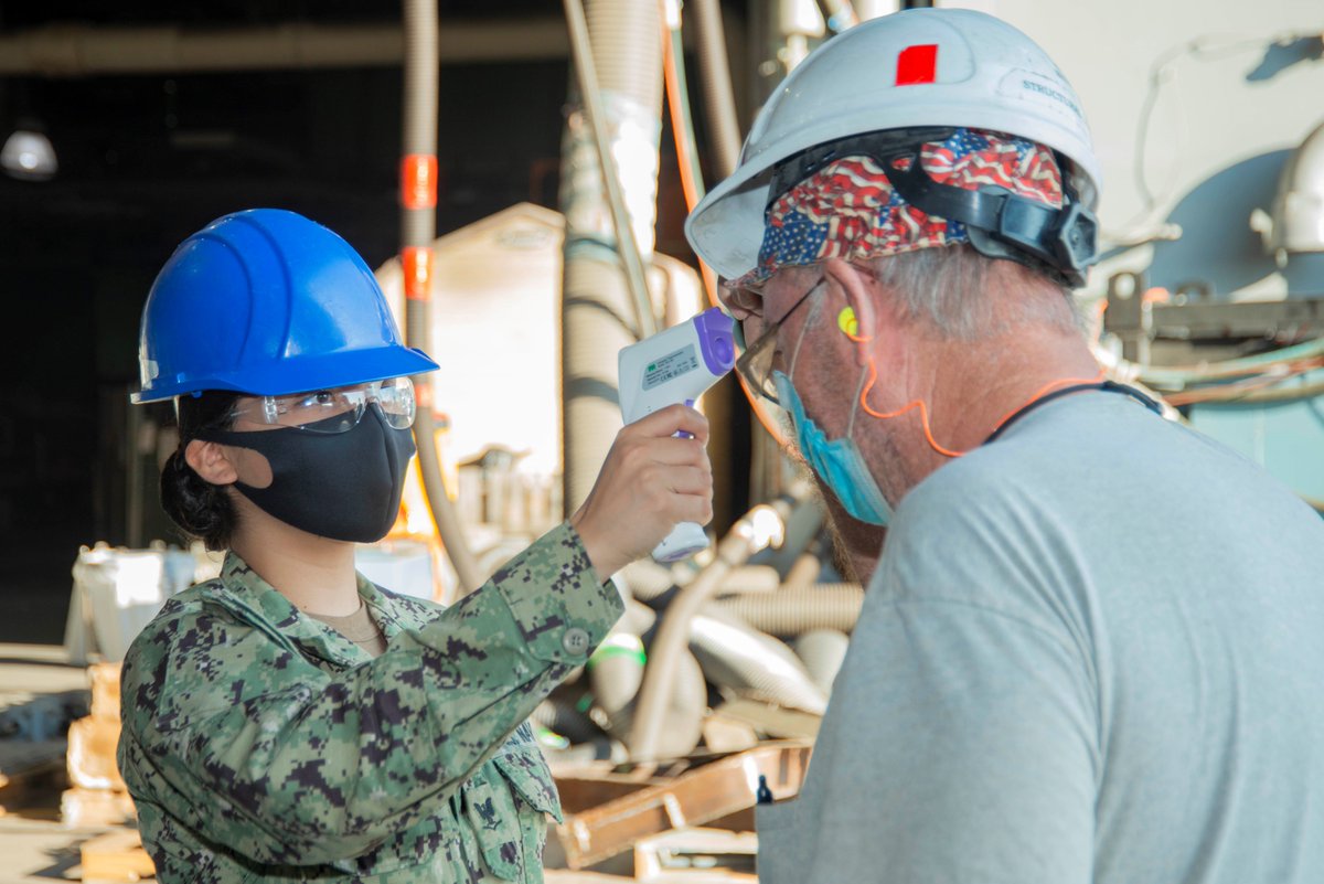 Aviation Boatswain’s Mate 3rd Class Erica Flores, a Sailor assigned to the air department aboard the Nimitz-class aircraft carrier USS George Washington (CVN 73), takes a civilian contractor’s temperature as he crosses the quarterdeck. (U.S. Navy photo by MC3 Adam Ferrero)