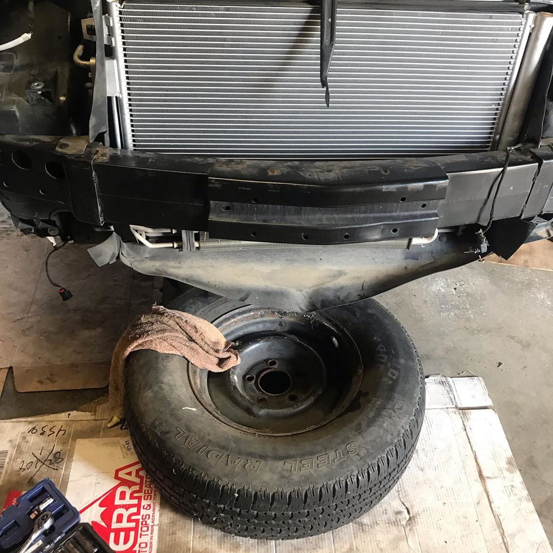 Rebecca Barlow @RebeccaBarlow (unseen) shows a tire with "Steel Radial" written on the contour. The tire is on cardboard that appears to read "TERRA" (the "T" is covered), and it is underneath an unknown vehicule. Rebecca placed a dirty beige towel on top of the tire, on its left side, and part of her toolbox can be seen in the bottom left of the photo.