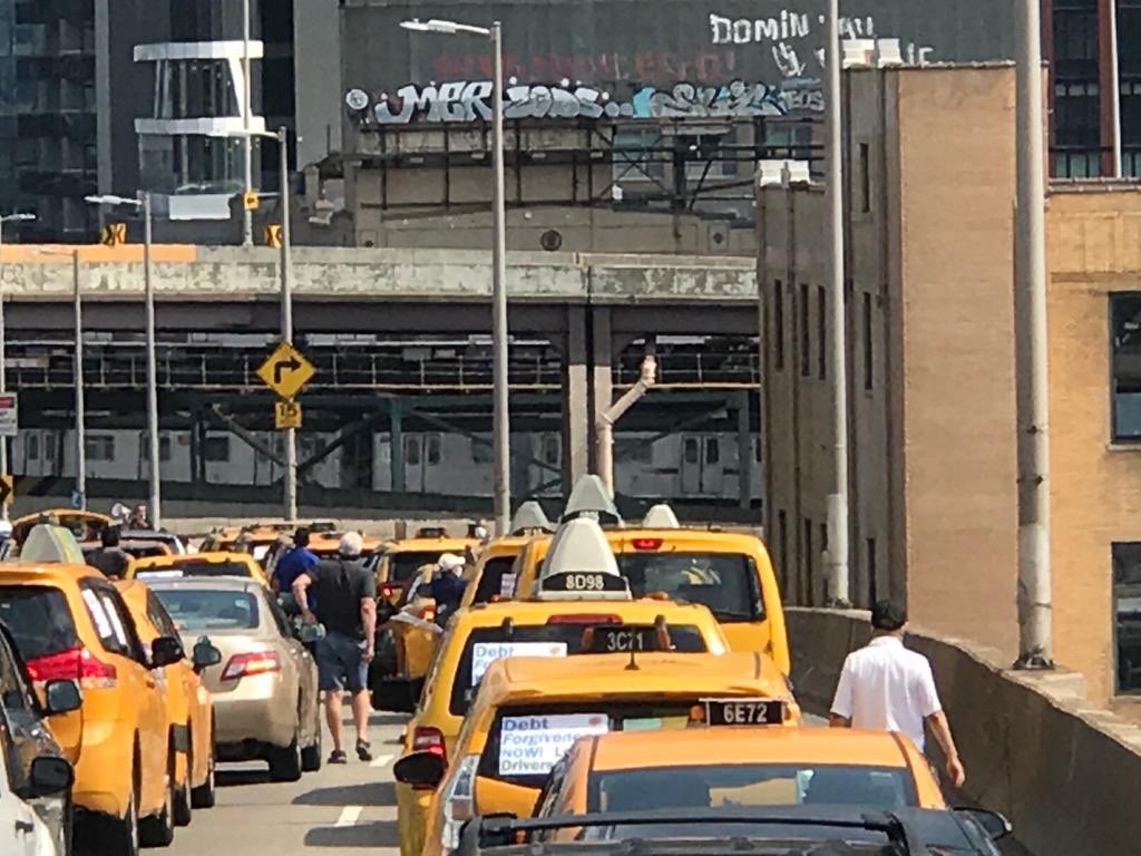 NYTWA's tweet image. SHUT IT DOWN! Yellow cab drivers are protesting on the Queens Borough Bridge demanding debt relief so we can live!