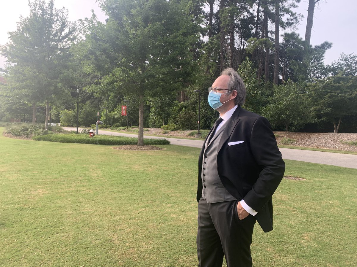 KateMurphyNews's tweet photo. At @NCState for what @WorkersAtState protesters call a “preemptive funeral” for student, faculty and staff lives that will be lost from COVID-19. They brought body bags and a wooden casket. Also a Chancellor Randy Woodson impersonator gave a eulogy and keeps saying “Go Pack!” https://t.co/KqwUnXdLYs