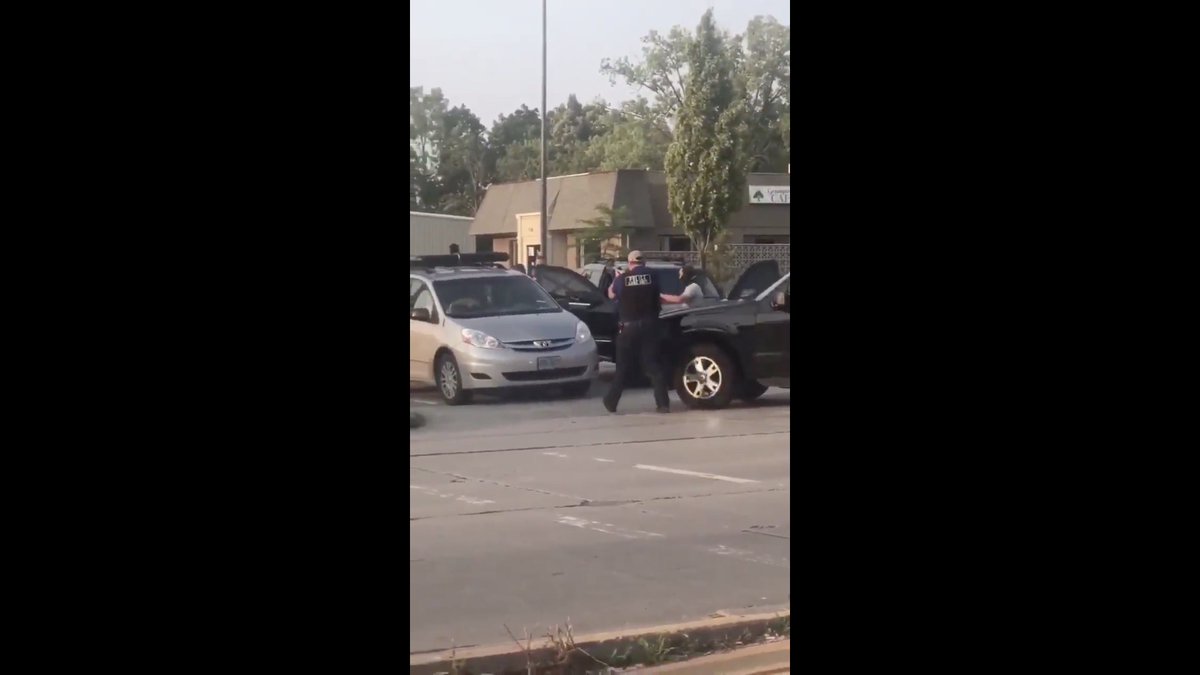 One plainclothes Special Operation Group (SOG) operator in a black hood yanks the lock out of the car door.Look at his physique.No doubt he's SOG.