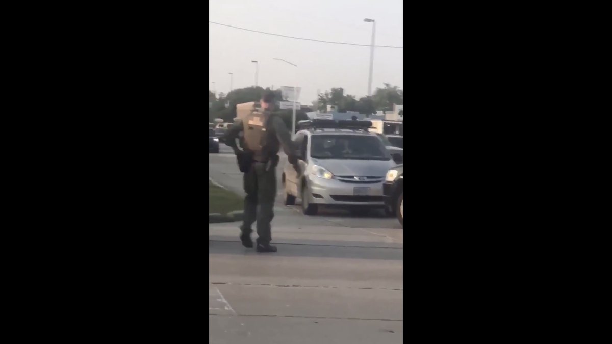 Then a uniformed SOG operator joins the party.Badge on belt, "US MARSHALS" on the back of his vest.There's a fully armed tactical squad in that SUV.