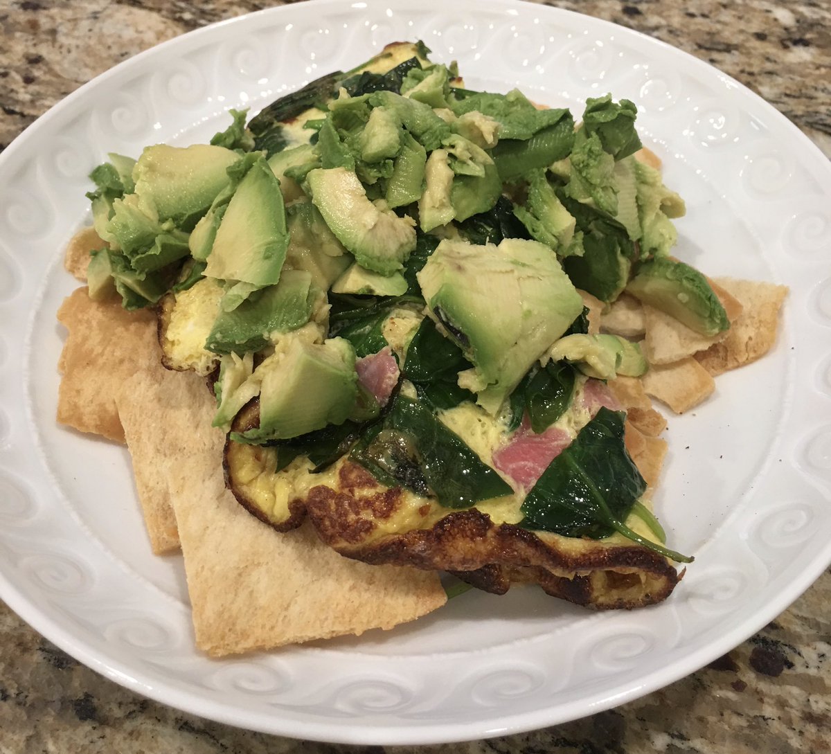 Spinach omelette with tomatoes over pita chips topped with avocado and scallions. #foodology #yum #flavor #crunch #breakfast