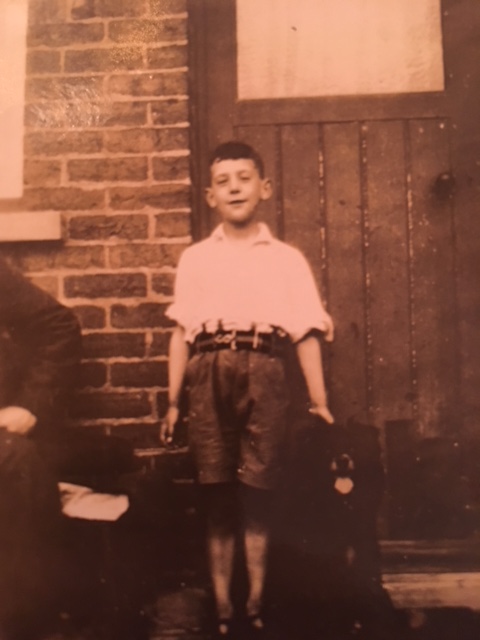 Recently, my parents dug out some old photographs, and I was struck especially by the ones of my grandfather. Here is the earliest one we have. He’s just a boy here, with the first of what turned out to be many dogs at his feet.