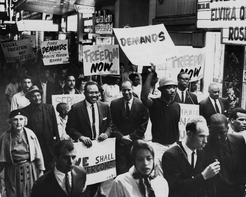 Civil rights demonstrators sing, wave signs during Los Angeles march. Nearly 3,000 joined in the march hailed by Negro leaders as largest on the West Coast.