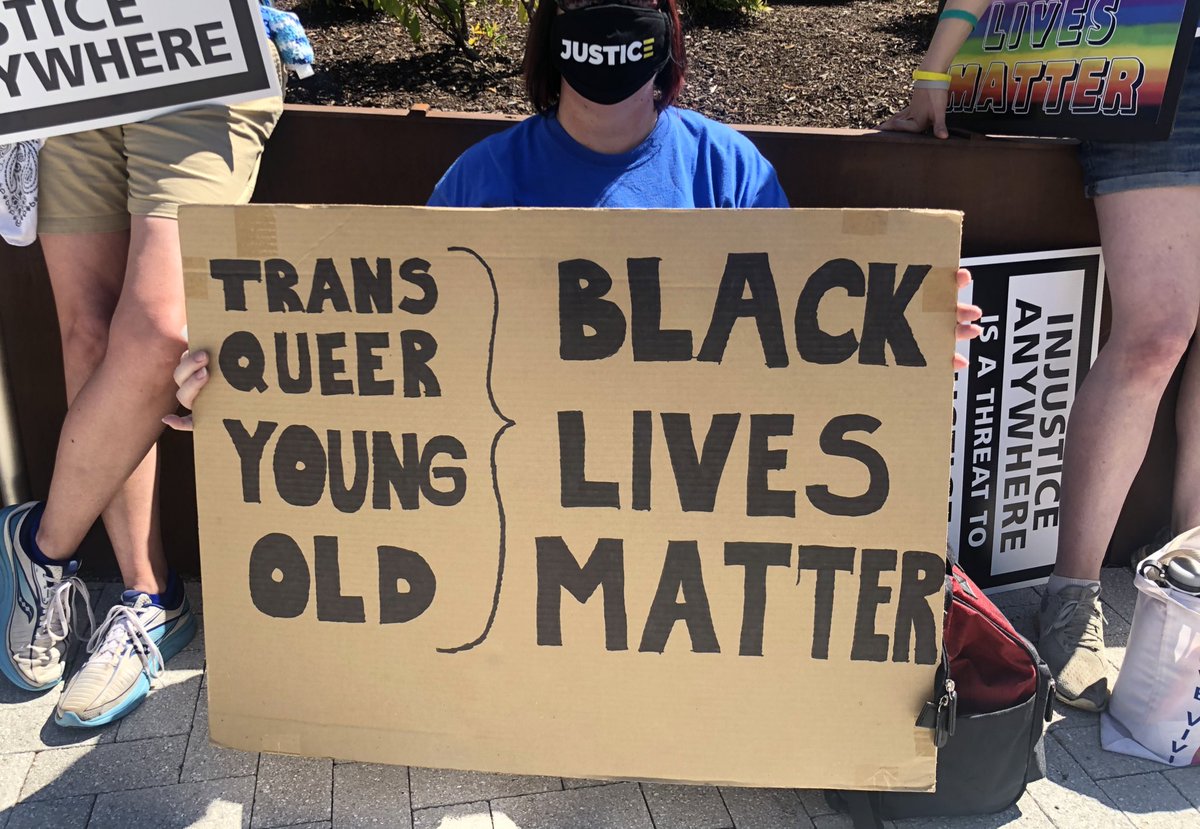 Here are some signs among the crowd: “HERE TO AMPLIFY BLACK VOICES”“IF NOT US, THEN WHO? IF NOT NOW, THEN WHEN?” “BLUE IS NOT A SKIN COLOR”“TRANS QUEER YOUNG OLD / BLACK LIVES MATTER”