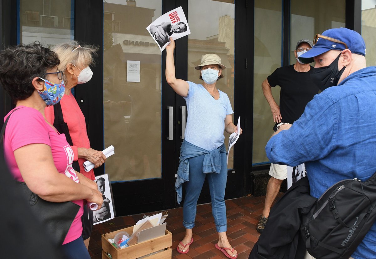 Melissa Newman, daughter of Paul Newman, hawks some register to vote posters today to passersby on Main Street. She came across the poster from the 1960s, eliminated a partisan message, and decided to hand them out as part of a get-out-the-vote effort. WN photo